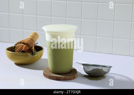 Iced matche Green Tea Latte with Creamy Foam on White Table Stock Photo