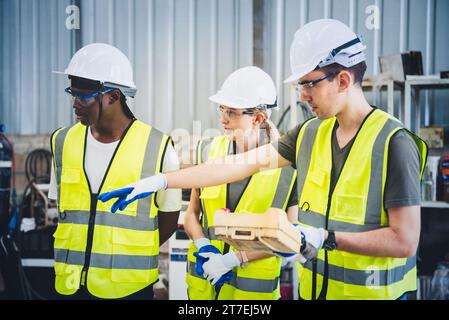 Engineers team mechanic using computer controller Robotic arm for welding steel in steel factory workshop. Industry robot programming software for aut Stock Photo