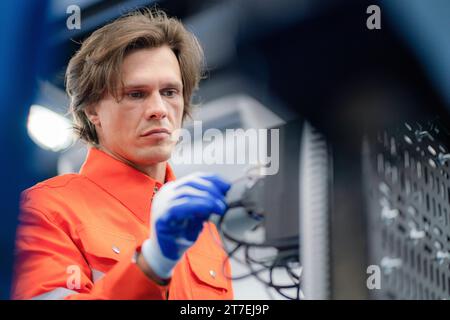 Electrical engineer checking Power Distribution Cabinet in the control room for industrial production. Stock Photo