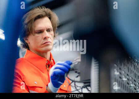 Electrical engineer checking Power Distribution Cabinet in the control room for industrial production. Stock Photo