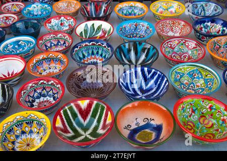 BUKHARA, UZBEKISTAN - SEPTEMBER 11, 2022: Multi-colored bright bowls with traditional national painting. Souvenir tableware of Uzbekistan Stock Photo