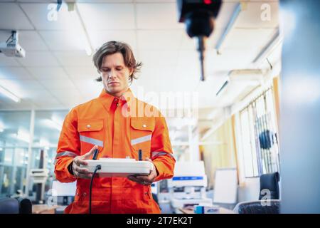 Mechanical engineer using coordinate measuring machine CMM measurement technologies at production line in the industry factory. Stock Photo