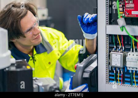 Electrical engineer work tester measuring voltage and current of power electric line in electrical cabinet control for industrial production. Stock Photo