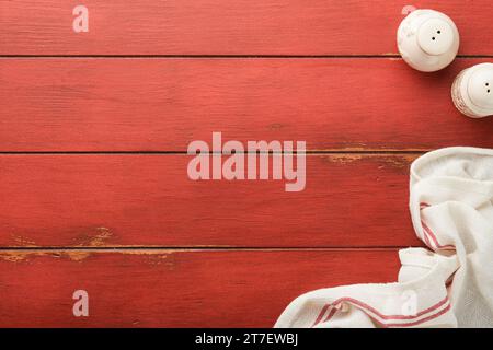 Food cooking empty background. Cooking kitchen napkin, salt and pepper shakers on old red background. Abstract food background. Recipe card, frame or Stock Photo