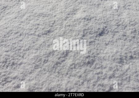 Beautiful winter background with snowy ground. Natural snow texture. Wind sculpted patterns on snow surface. Stock Photo