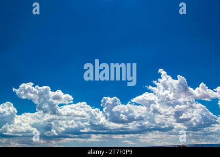 sunlit clouds in a bright blue sky Stock Photo