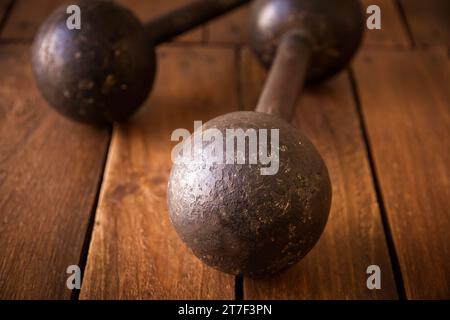 Old rusty dumbbells on rustic wood board background texture Stock Photo