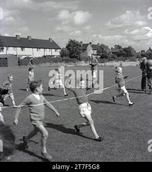 1960s, historical, school sports day, primary school children competing in a running race...we see a close finish at the finishing tape, England, UK. Stock Photo