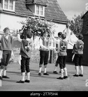 1960s, historical, adult men and male youngsters dressed in costumes doing a morris dance, England, UK. Morris dancing is a popular form of English folk dance performed at festivals and holidays to celebrate the coming of summer and autumn's golden harvest. Stock Photo