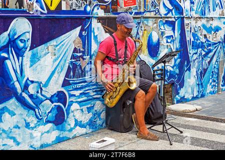 Busker playing saxophone in front of mural in the city centre of capital Montevideo, Uruguay, South America Stock Photo