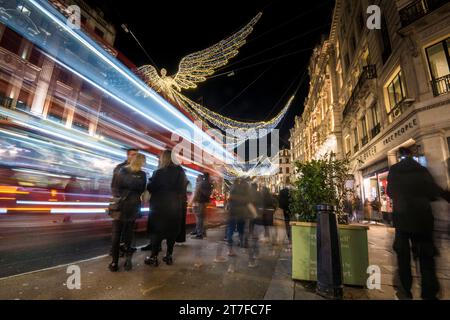 London, UK.  15 November 2023.  Traffic passes under the annual Christmas lights on Regent Street which have been switched on recently.   West End retailers are hoping for increased footfall during the festive season.   Credit: Stephen Chung / Alamy Live News Stock Photo