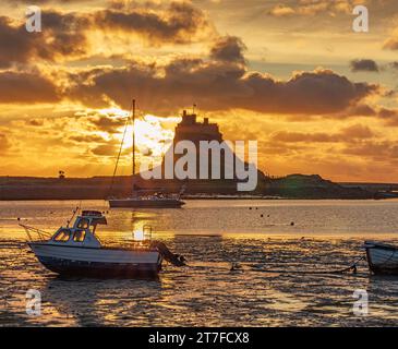 Sunrise in Summer over Lindisfarne Castle on the Holy Island of Lindisfarne In Northumberland as seen from the harbour Stock Photo