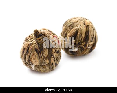 Floral green Chinese tea, tied tea balls with dried flowers, blooming fragrant tea isolated on white background. Stock Photo