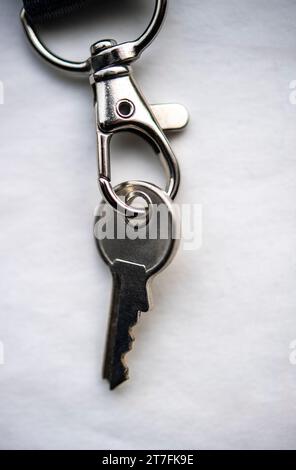 Close-up of a small silver key on a key chain holder Stock Photo