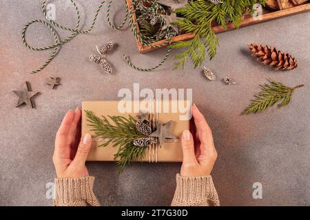 Christmas decor and Womans hands decorating handmade gift box Stock Photo