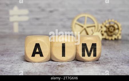 Ambition, mission and objective concept. Wooden cubes with text AIM and archery target with arrows icon Stock Photo