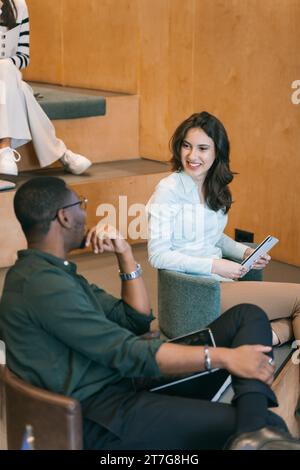 Diverse coworkers taking a break. Multiracial colleagues, male and female, having fun conversation and smiling on a break Stock Photo