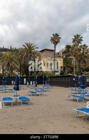 The promenade from the beach with Villa Argentina and the fortress of Castelfranco (1375) in the background, Finale Ligure, Savona, Liguria, Italy Stock Photo