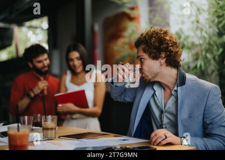 Architectural Team Discussing Blueprint at Coffee Bar Stock Photo
