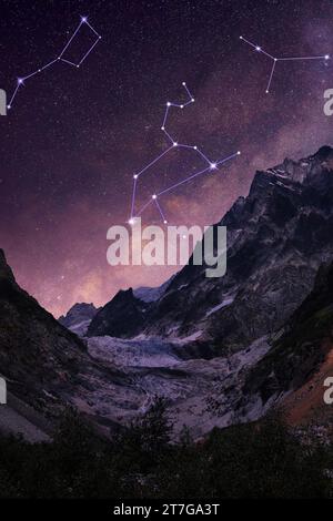 Different constellations in starry sky over mountains at night Stock Photo
