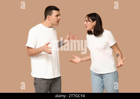 Young couple arguing with expressive hand gestures on beige background Stock Photo