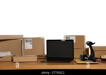 Parcels, laptop and barcode scanner on wooden table against white background. Online store Stock Photo