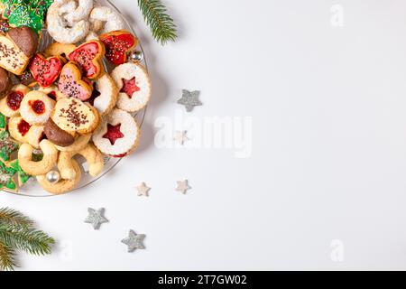Glass plate with various Christmas biscuits, Christmas decorations, white background, copy room Stock Photo