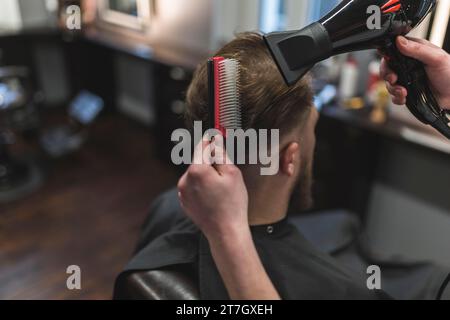 From barber combing drying hair client Stock Photo