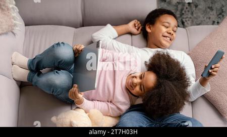 Siblings using tablet mobile home 3 Stock Photo