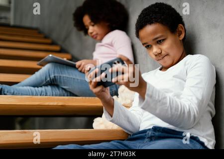 Siblings home using mobile tablet Stock Photo