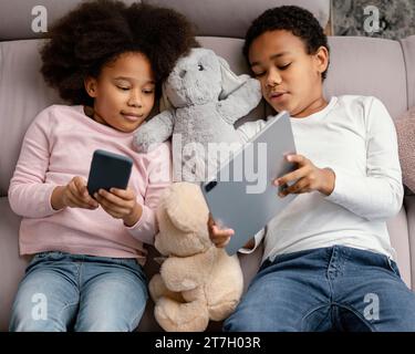 Siblings using tablet mobile home Stock Photo