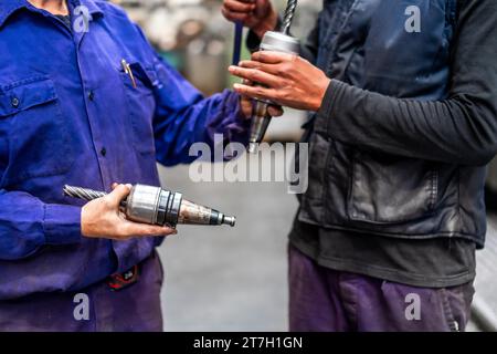 Unrecognizable operators with numerical control metal industrial factory machine tools Stock Photo