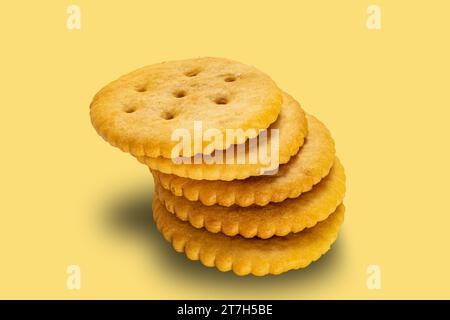 High angle view stack of salted round crackers isolated on yellow background with clipping path Stock Photo