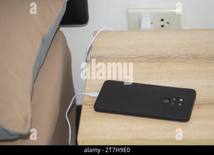 Charging smartphone on the bedside table Stock Photo
