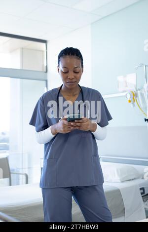 African american female doctor using smartphone in hospital room Stock Photo