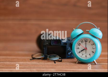 travel plan ideas with alarm clock Camera for vacation planning on brown wooden table background Stock Photo