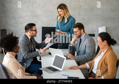 Successful business professionals presenting analytical report, working together in corporate office Stock Photo