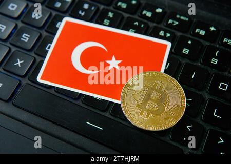 Golden bitcoin and flag of Turkey on keyboard of the laptop, cryptocurrency trading technology concept. Stock Photo