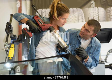 glazier using silicone tools repairing to fix crack broken windscreen Stock Photo