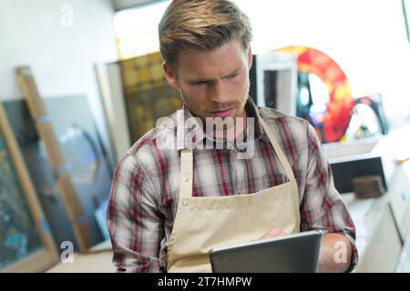 shoemaker using digital tablet in workshop Stock Photo