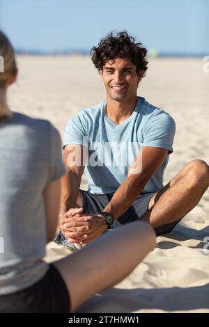 couple meditating on beach from back Stock Photo