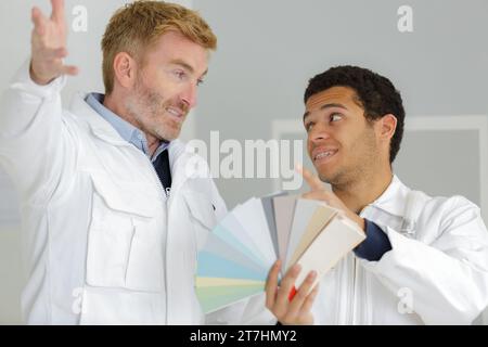 close-up of two architects choosing color from various colorful swatches Stock Photo