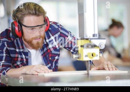 young man with a beard using a milling machine Stock Photo