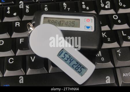 Two SecureID Tokens sitting on a computer keyboard Stock Photo