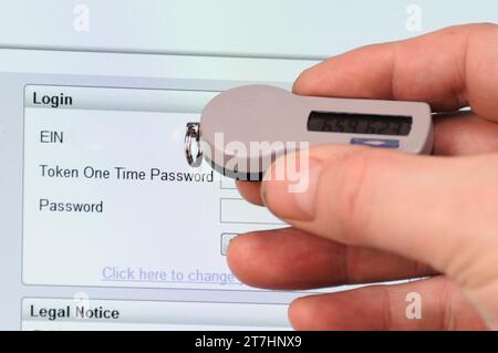 Man uses SecureID token to log into a website needing a userID, Passcode and Password Stock Photo