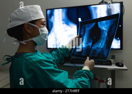 Asian female surgeon looking at x-ray scans in operating theatre at hospital Stock Photo