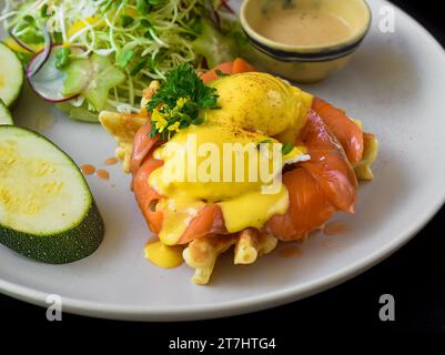 white plate with eggs bennedict waffles with smoked salmon on a white background Stock Photo