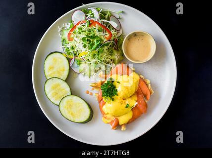 white plate with eggs bennedict waffles with smoked salmon on a white background Stock Photo