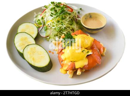 white plate with eggs bennedict waffles with smoked salmon on a white background Stock Photo