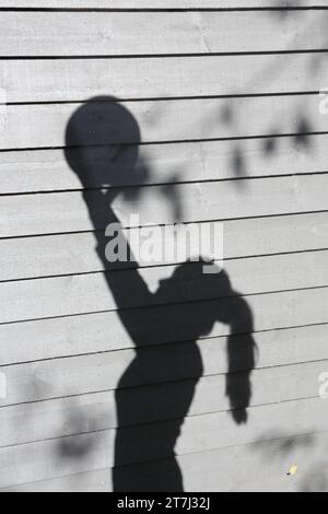 Teenage girl volleyball shots shadow of arms up holding ball Stock Photo